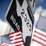 Flags fly next to a Texas road sign