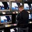 A customer looks over flat-panel TVs at a Best Buy