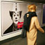 A commuter walks past a clown ad in Paris