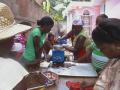 Women grinding cocoa beans in Haiti