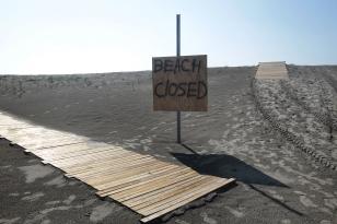 A sign marks a beach closed due to the Deepwater Horizon oil spill in Grand Isle, La., Thursday, May 27, 2010.