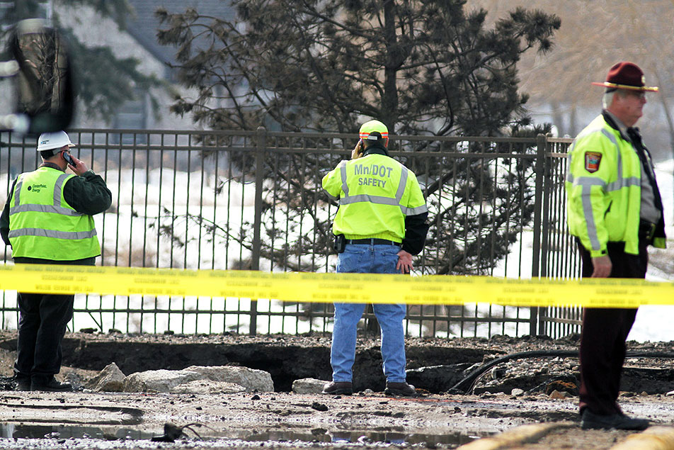 MnDOT workers examine hole