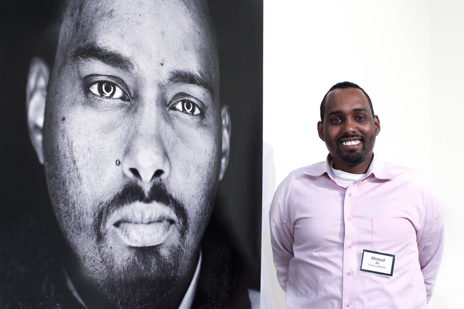 Ahmed Ali poses beside his portrait