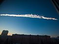 Contrail over buildings