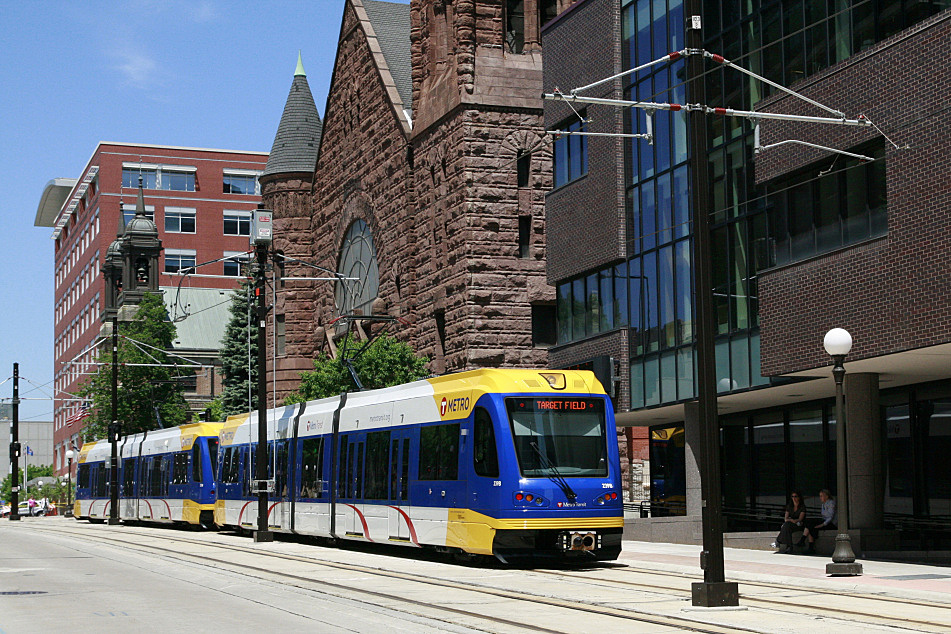 A Metro Transit Green Line train passes the MPR building and the Central Presbyterian Church in downtown St. Paul, Minn.