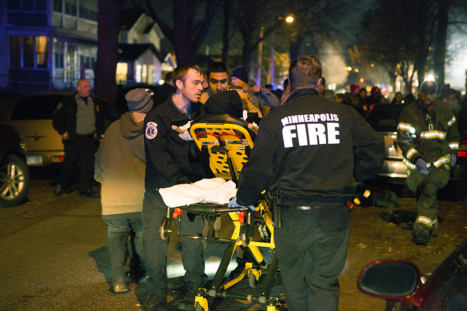 Paramedics took a wounded man to an ambulance. He had been shot in the leg at the 4th Precinct in Minneapolis.